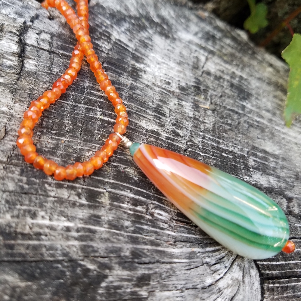 Agate pendant on carnelian necklace strand.